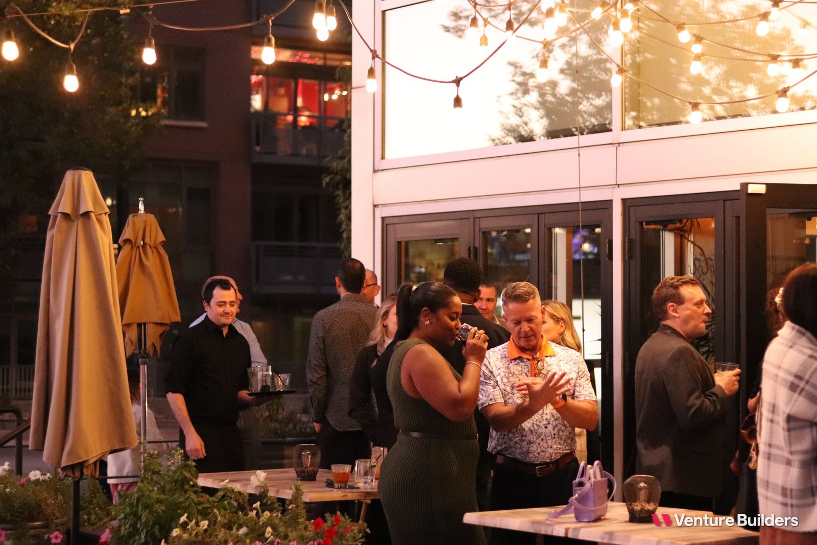 Guests on the patio at the Venture Builders dinner in Denver at golden hour